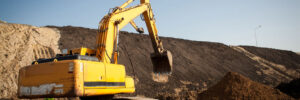 A large construction excavator of yellow color on the construction site in a quarry for quarrying