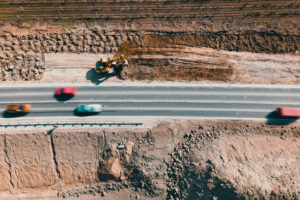 Construction Of Road, Road building. Grader and roller work making new road. Ground is levelled before asphalt can be laid. Aerial drone view