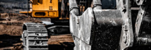 Yellow excavator steel bucket working on construction open mining site.