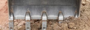 detail of excavator bucket with loam at a construction site
